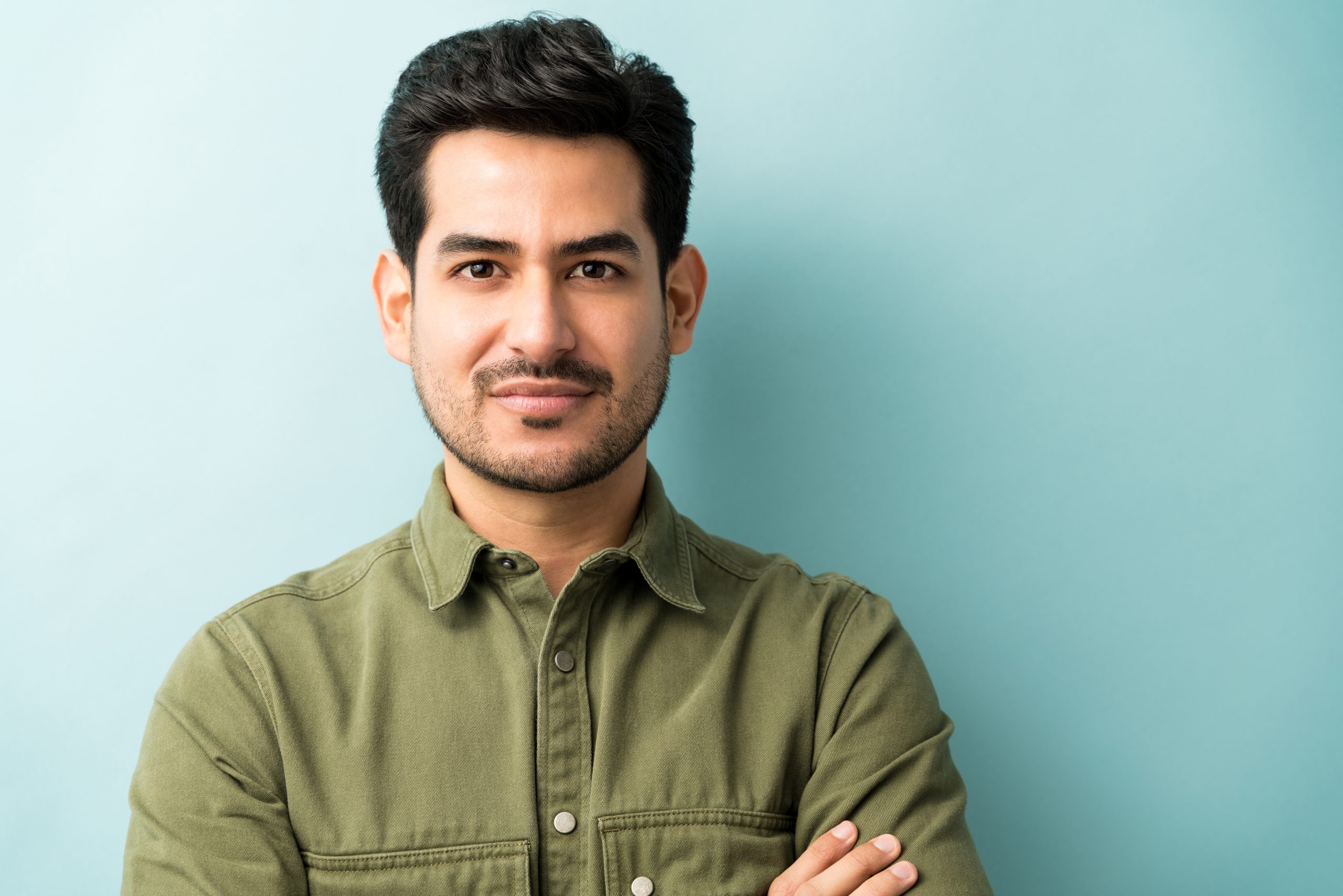 Closeup of young Hispanic man in casuals at studio