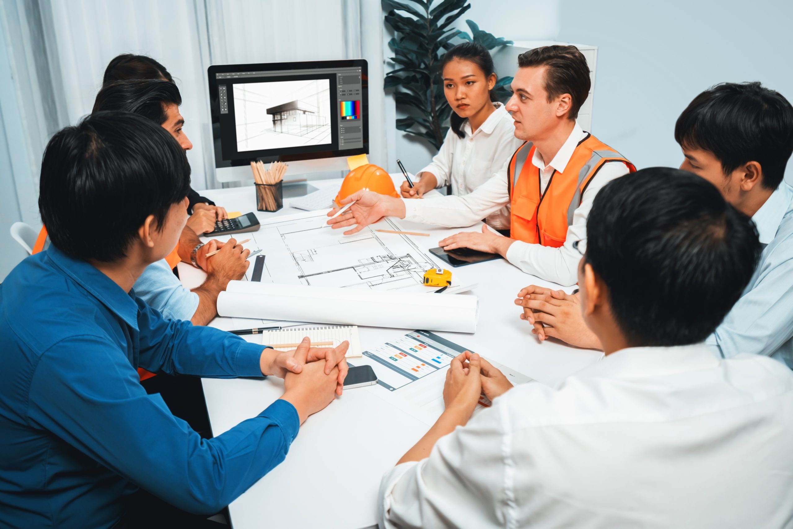 Diverse group of civil engineer and client working together on architectural project, reviewing construction plan and building blueprint at meeting table. Prudent